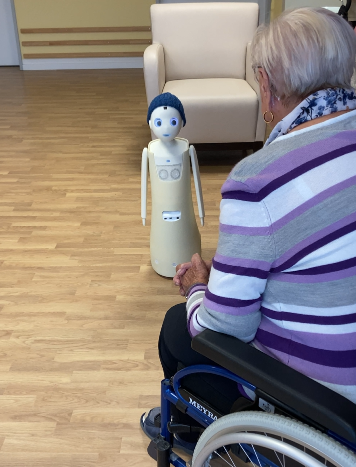 soziale Roboter Navel schaut Plegeheimbewohnerin in die Augen