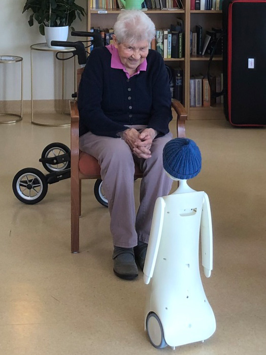 der soziale Roboter Navel unterhält sich mit einer Pflegebedürftigen in einem Pflegeheim